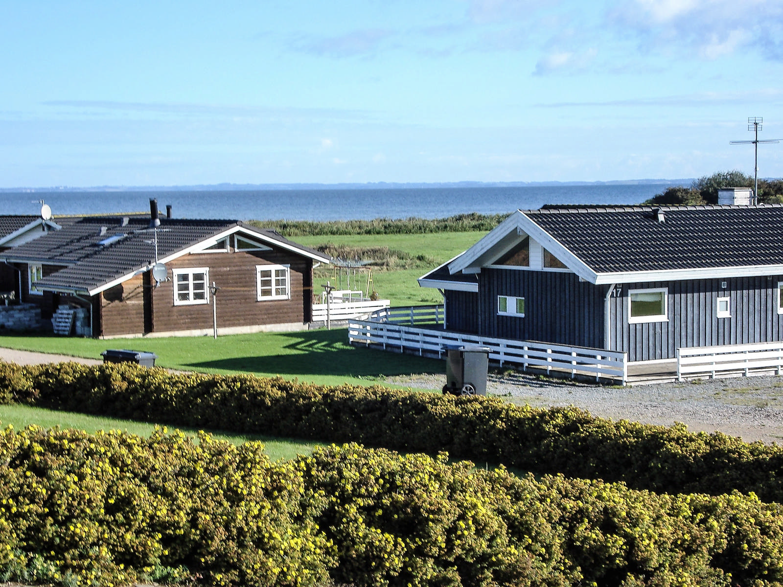 Sommerhuse med udsigt til vand i baggrunden